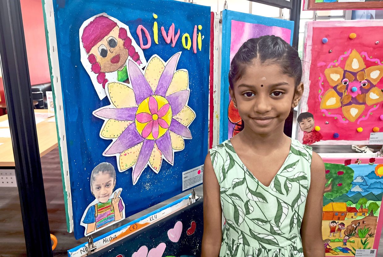 G. Keashikaa standing next to the painting she contributed for the art exhibition.