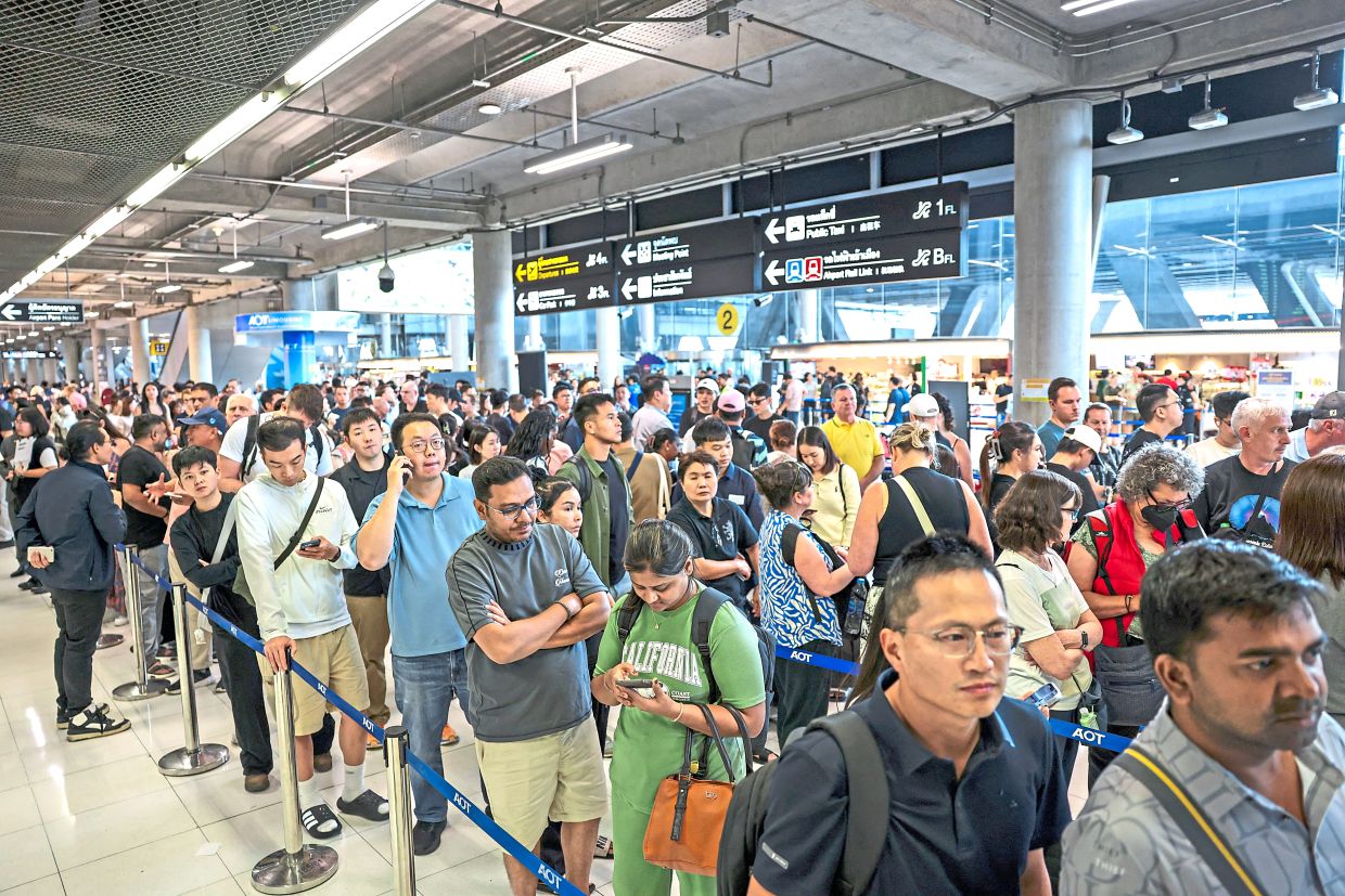 Airport chaos: Passengers queueing to claim baggage from their Thai Airways flights at Suvarnabhumi International Airport, after heavy rain and flooding disrupted the airline’s ground operations, in Bangkok. — Reuters