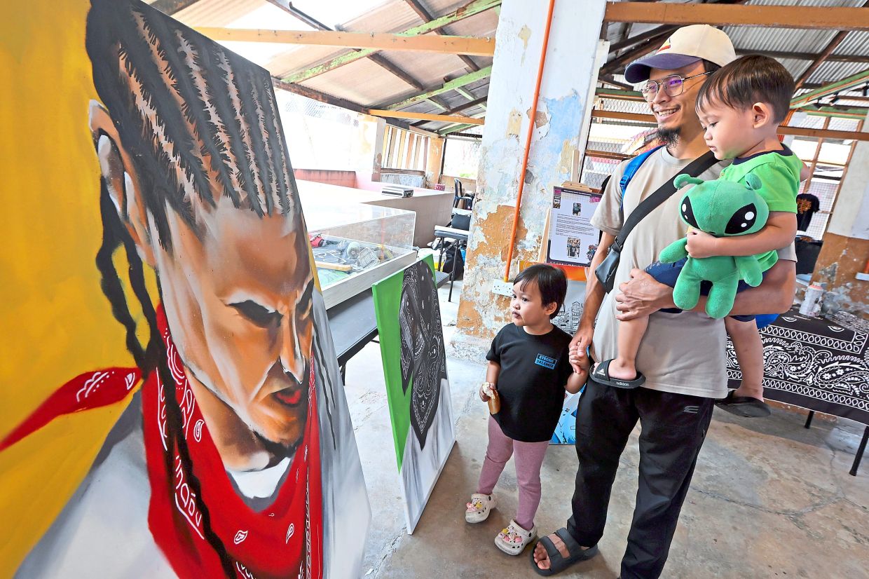 A visitor with his children looking at an artwork at the Graff For Nation 2.0 event.