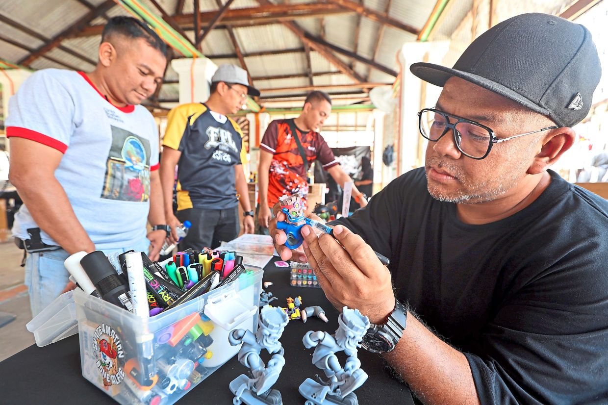 A local artist painting his designer toy at Graff For Nation 2.0.