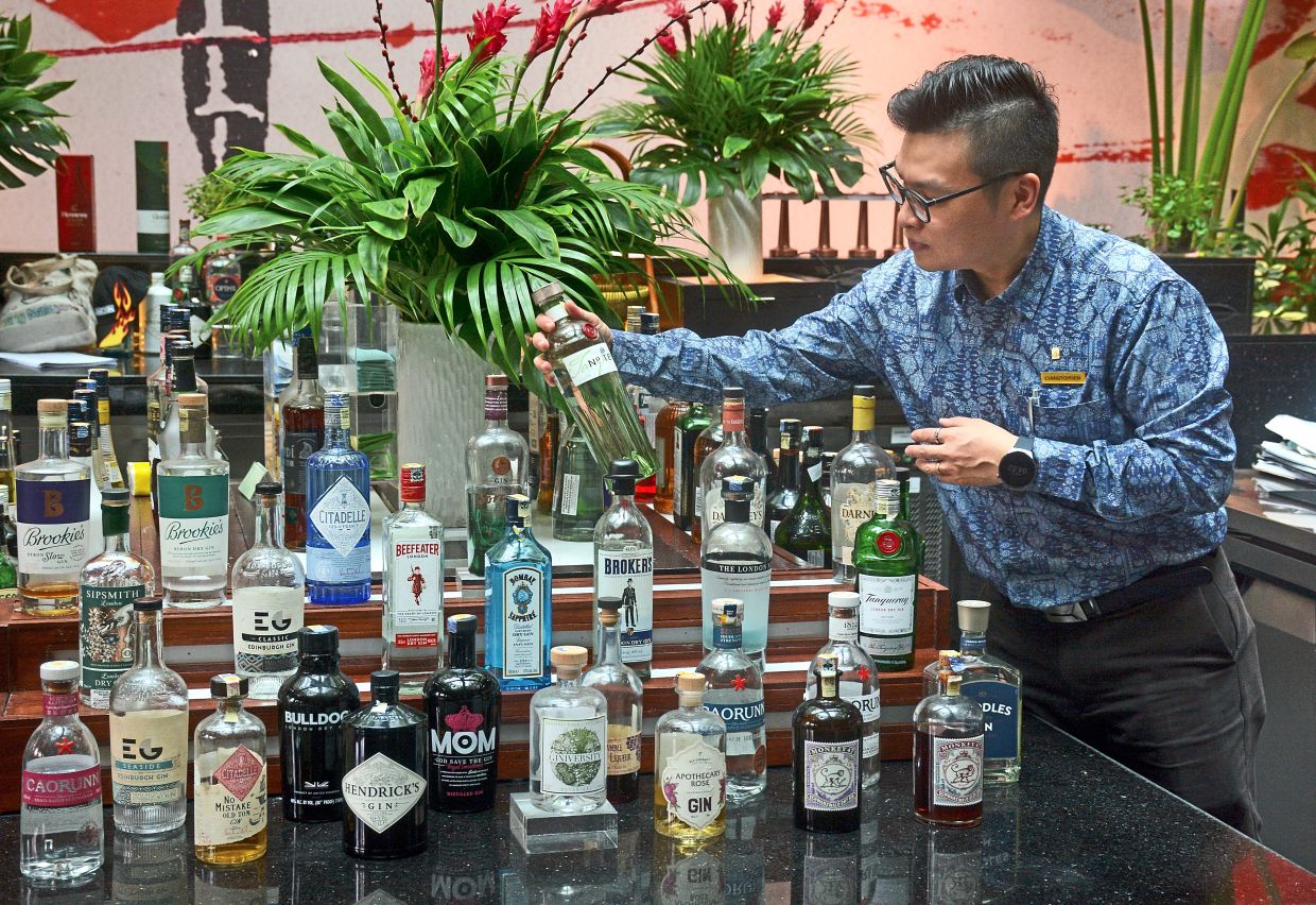 Ong selecting a gin to make one of Passion Garden’s signature cocktails.