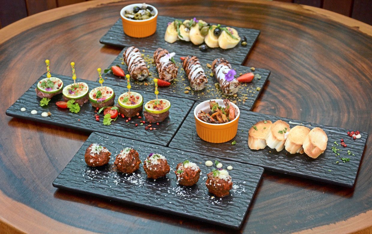 New tapas items to complement the gins – Black Angus Beef Balls (front), Sauteed Black Angus Beef Cubes (second row left), Spanish-style Garlic Pepperoncino Prawns (second row right), Stuffed Cannoli (third row), and Trio of Marinated Olives (back).