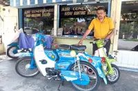A barber keeps vintage motorcycles on the road 