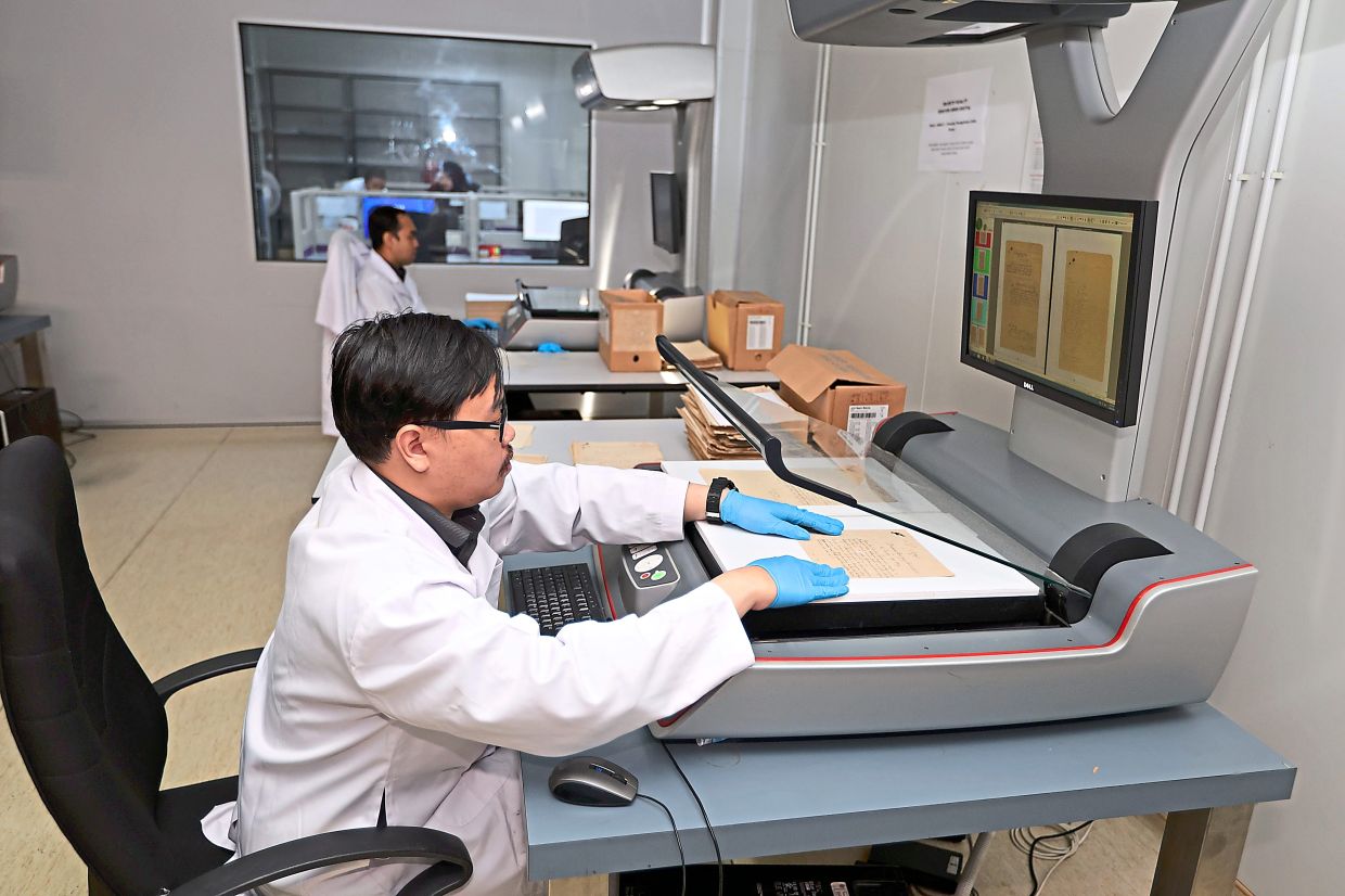 An archivist scanning a document for digital archiving.