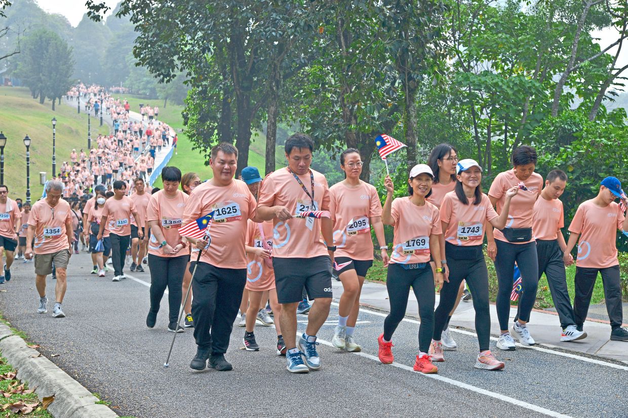 Volunteers accompanying visually impaired participants during Run For A Chance at Kepong Metropolitan Park. — Photos: Handout
