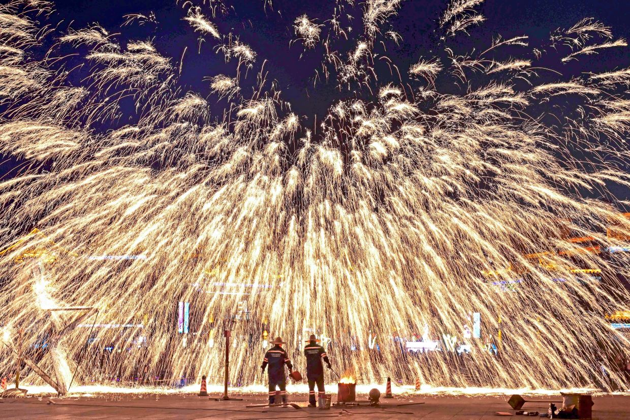 5. Folk artists performing a spectacular molten-iron fireworks display in an ancient town in Luoyang, Henan province, central China. — Xinhua