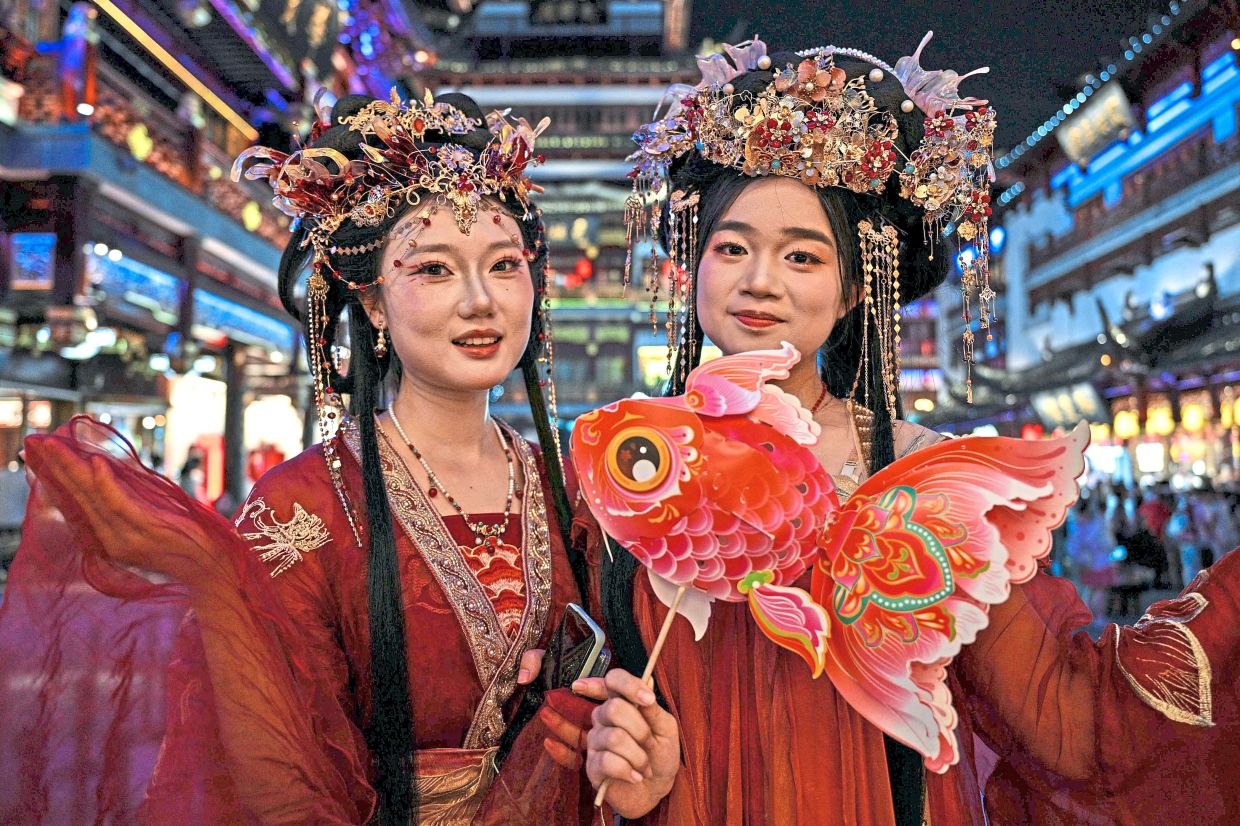 8. Women in traditional costumes pose for photographs in Yu Garden during Mid-Autumn Festival celebrations in Shanghai, China. — AFP