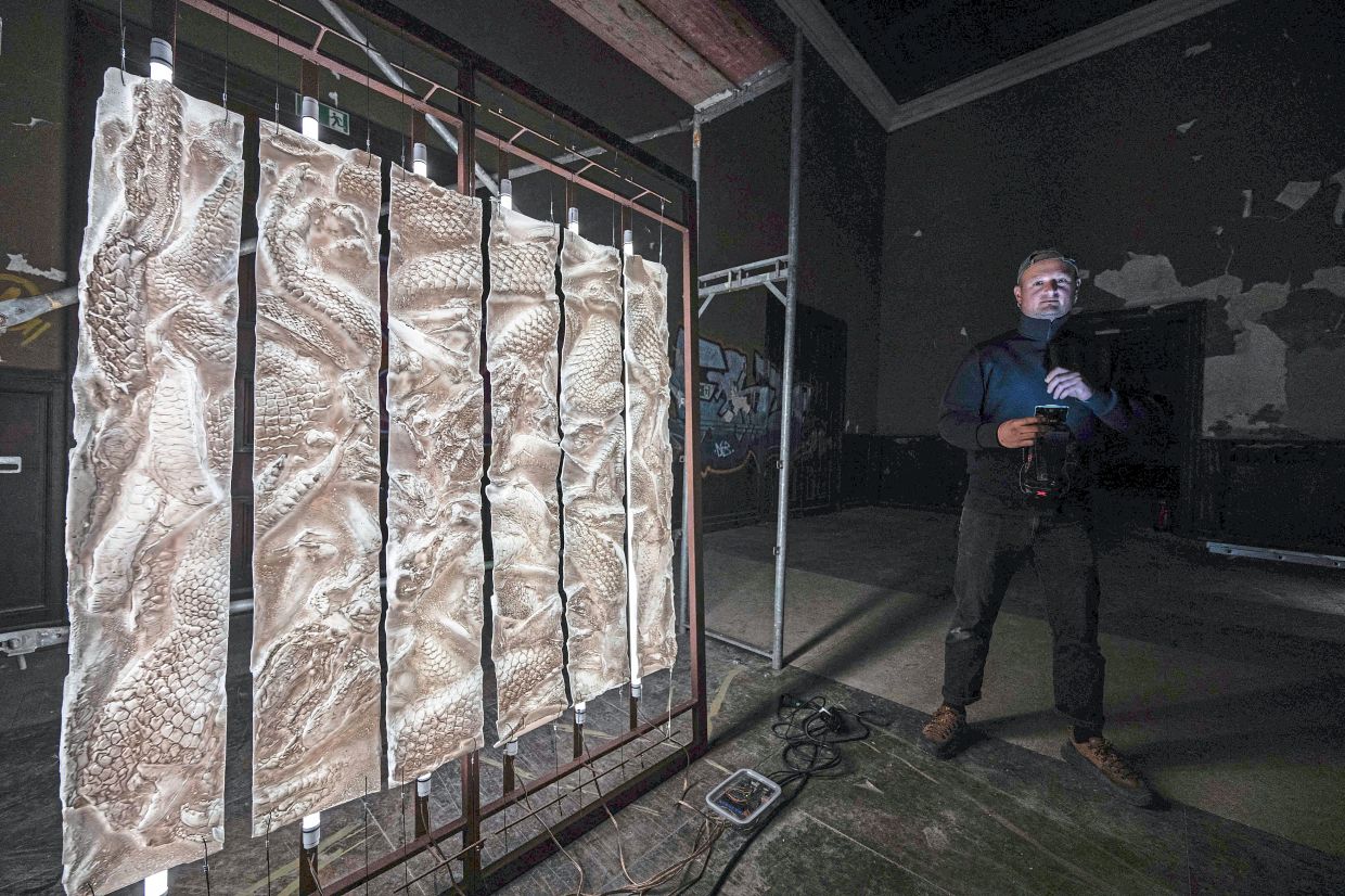 1. French artist Pierre Gaignard posing beside his work ‘Dragon GHz’ during a preview of the ‘Futur’ exhibition at a former World War II officers’ mess in Krampnitz, near Potsdam, Germany. The exhibition offers a space for commentary, observation and aesthetic reflection on the future in a former Nazi-era barracks later occupied by Soviet forces. — AFP
