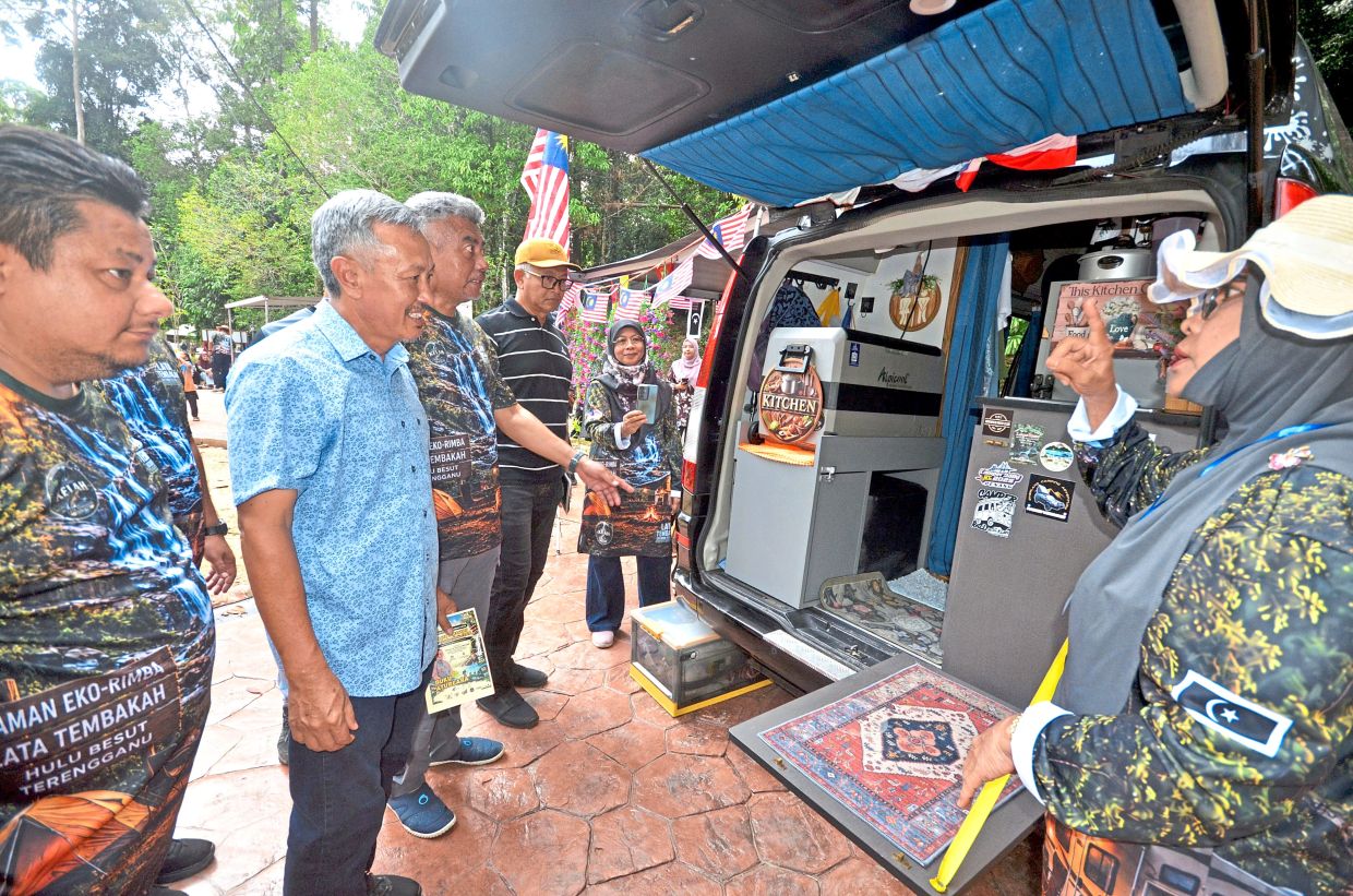 Khazan (left) checking out a camper van belonging to a participant of the Tembakah Waterfall Outdoor Festival.