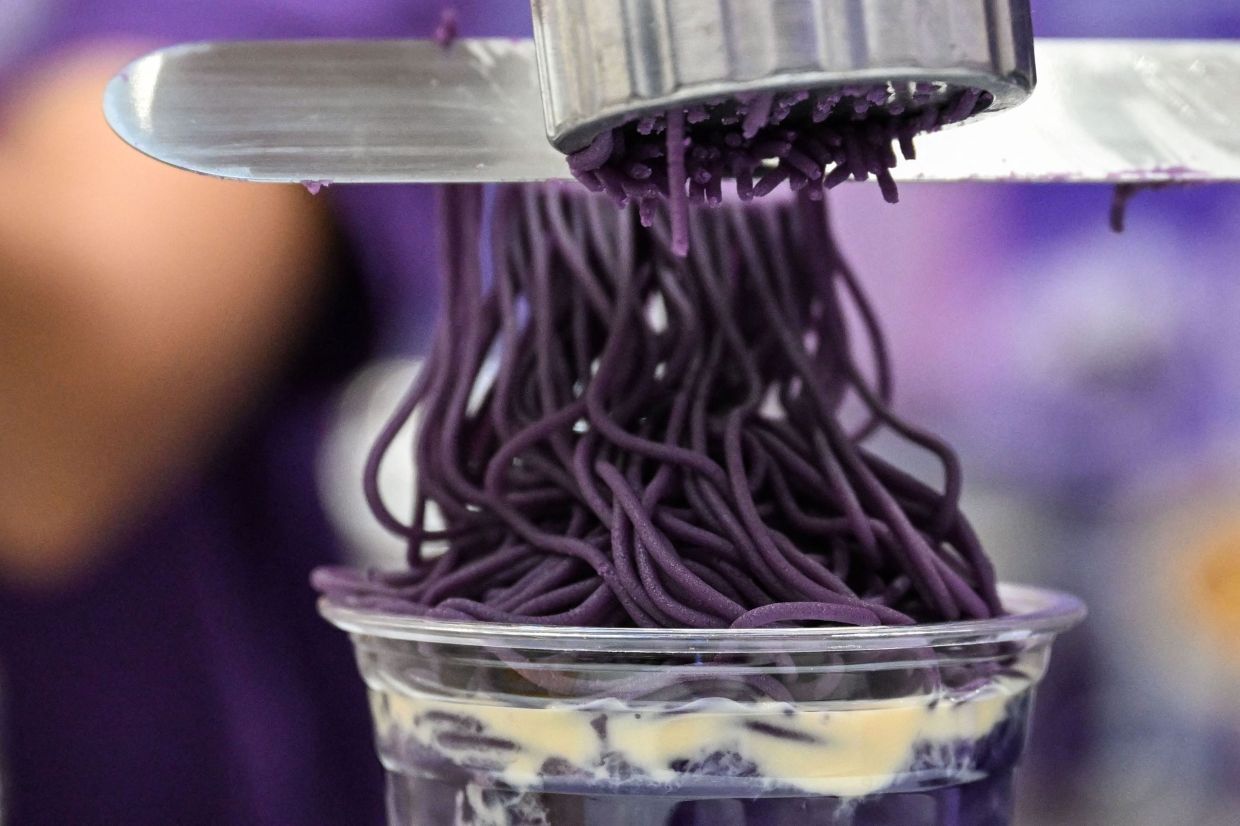 Ube halaya topping over sweet ube rice porridge (champorado) during a purple yam promotional event at a mall in Quezon City, Metro Manila. - AFP