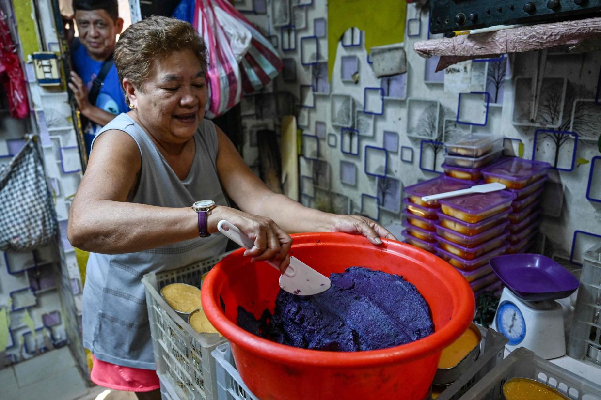 A worker preparing purple yam jam (ube halaya) at a shop in Manila. - AFP