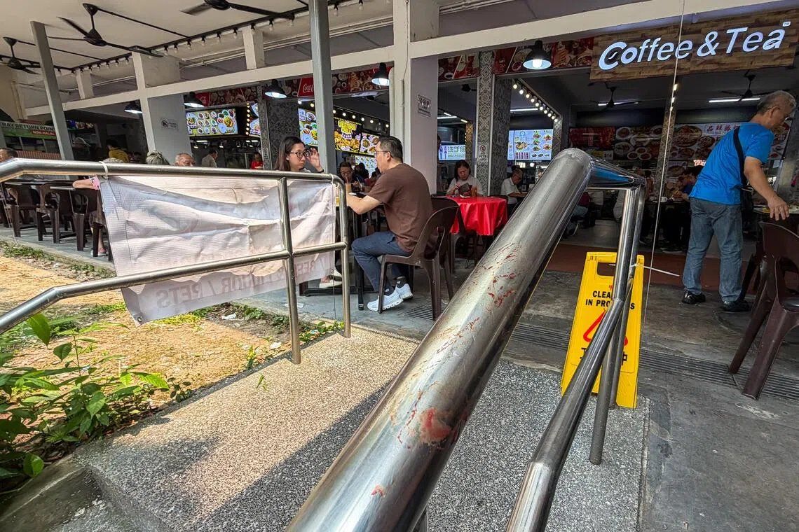 Dried bloodstains on a railing beside a coffee shop at 61 Telok Blangah Heights on Oct 6, near where a stabbing incident is believed to have occurred the previous evening. - Photo: ST