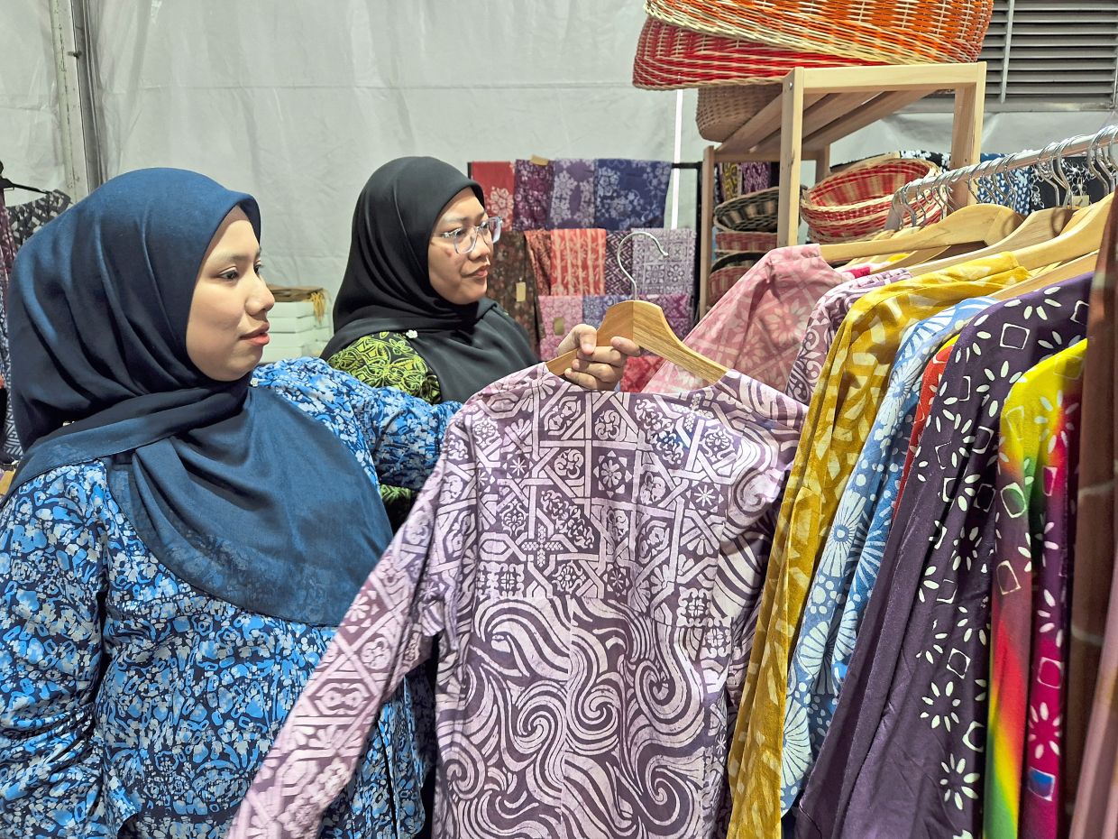 Neesha Nizam (left) and Nur Adilah Abdul Rahim admire outfits made from Perak batik.
