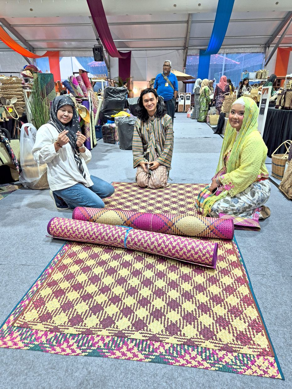 Visitors admire the intricate designs and vibrant colours of mengkuang mats at the craft fair.