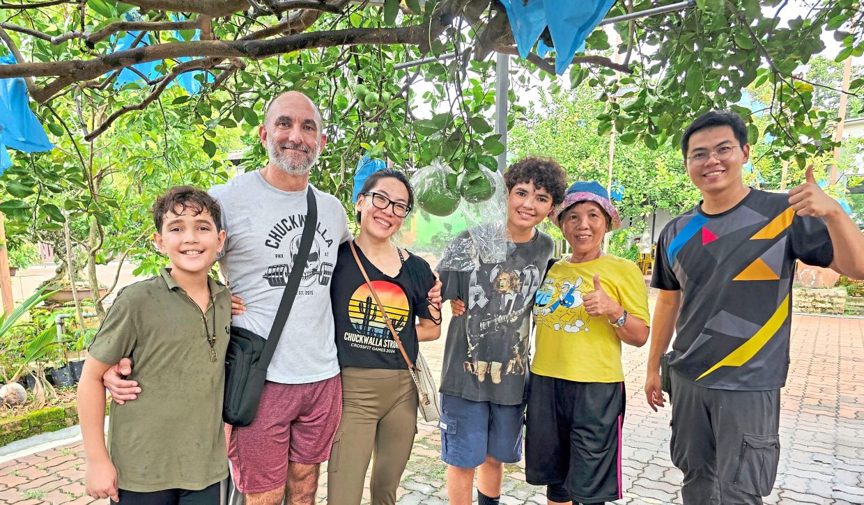 The writer (second from right) and her relatives at the pomelo farm, with their guide Yan Kuan (right).