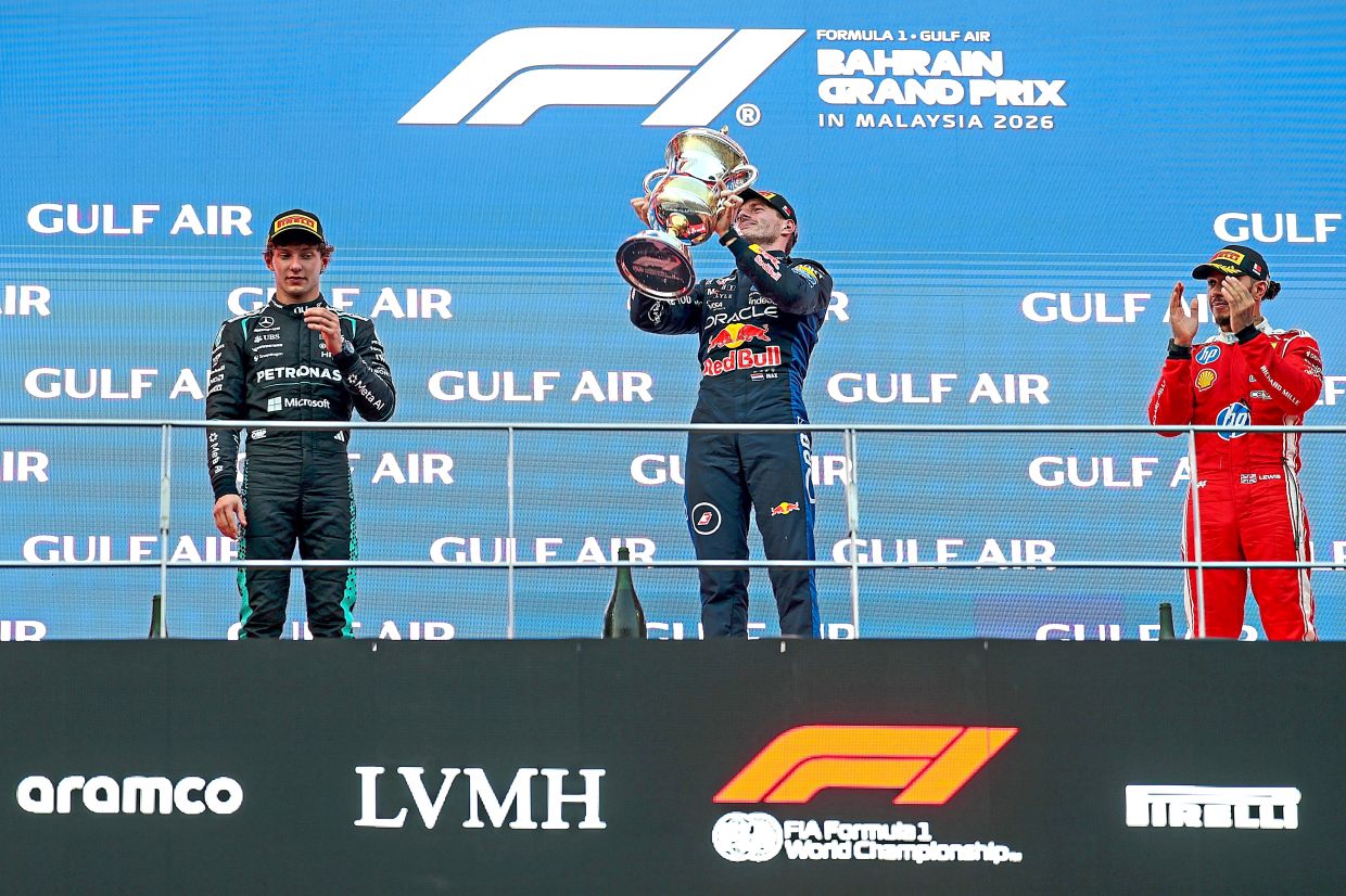 Verstappen celebrating on the podium flanked by Antonelli (left) and Hamilton after winning the Formula 1 Bahrain Grand Prix in Malaysia at the Sepang International Circuit.