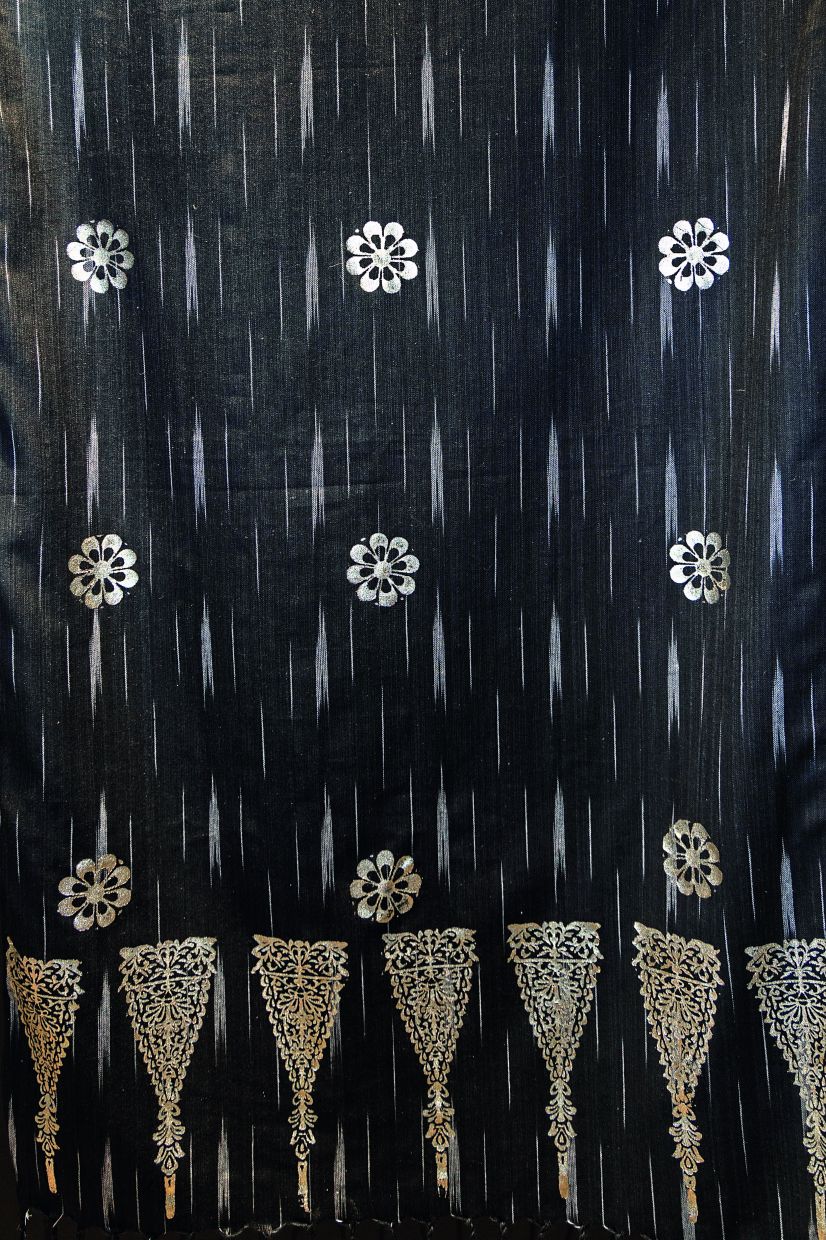 Royal Selangor craftsmen conducted trials applying tin leaf onto fabric using traditional stamping techniques.
