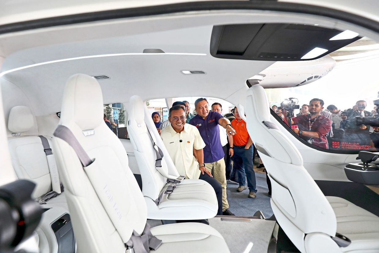 Amirudin taking a look at the interior of the E20 after the MOU signing.