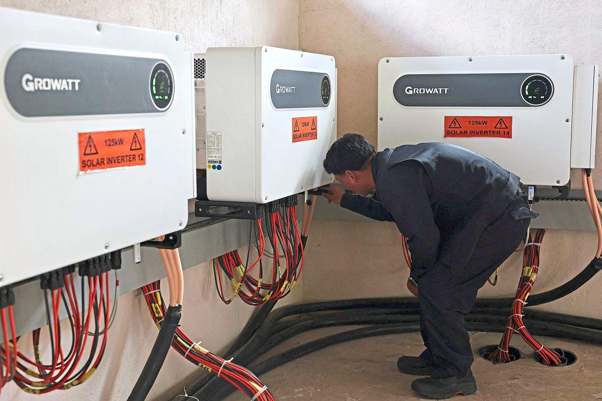 Rinzin checking solar inverters in a control room at the Norion Renewable Energy company compound in Thimphu.— AFP