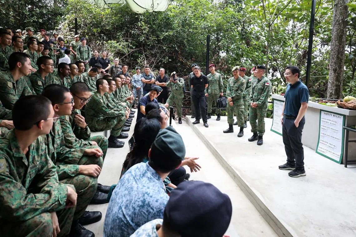 Lawrence Wong (right) and Defence Minister Chan Chun Sing (in black) meeting SAF personnel training in Temburong. -- PHOTO: MDDI/The Straits Times - Asia News Network