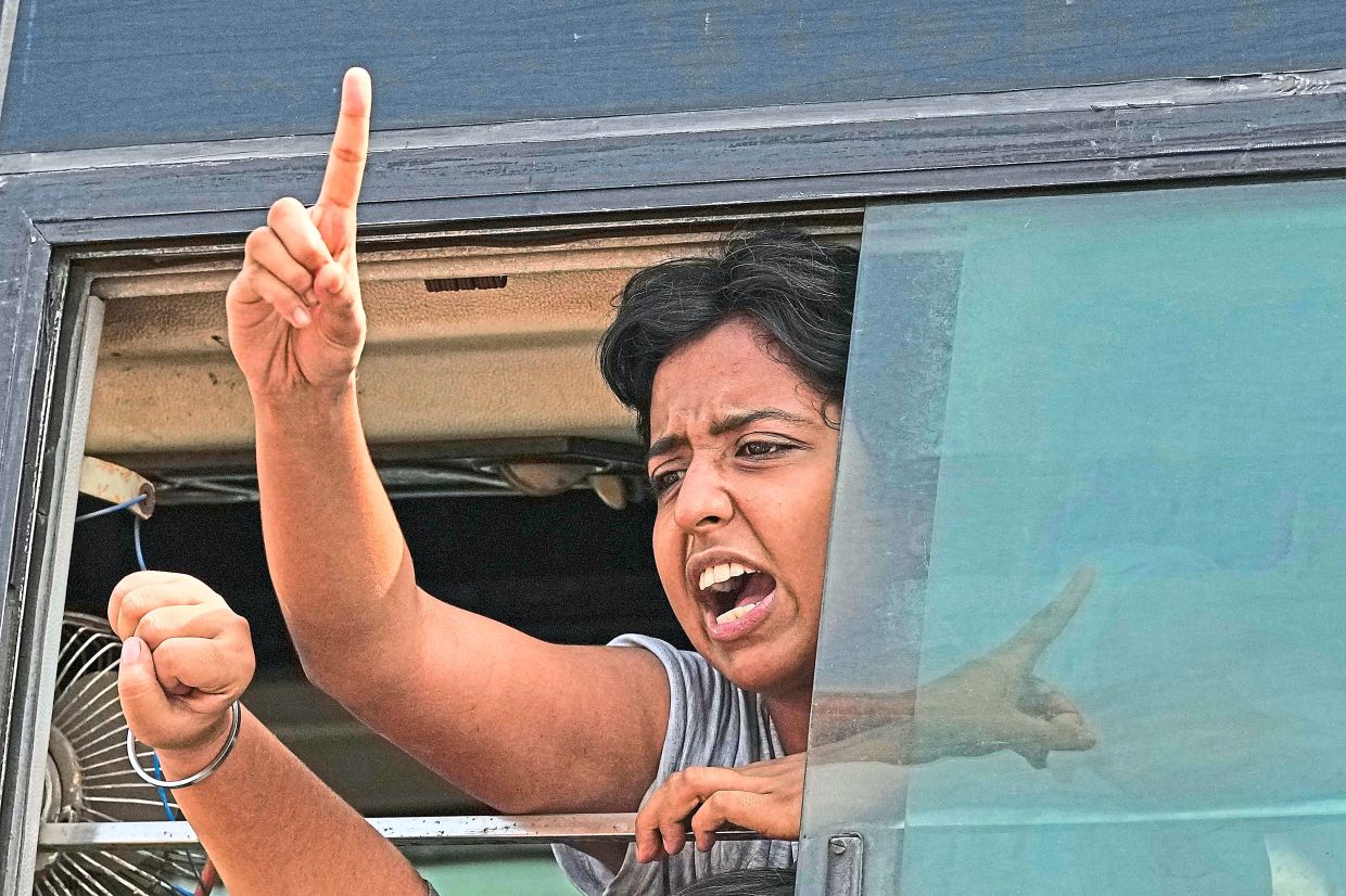 Taking a stand: A protester shouting slogans after being detained and taken in a police vehicle during the rally in New Delhi. — AP