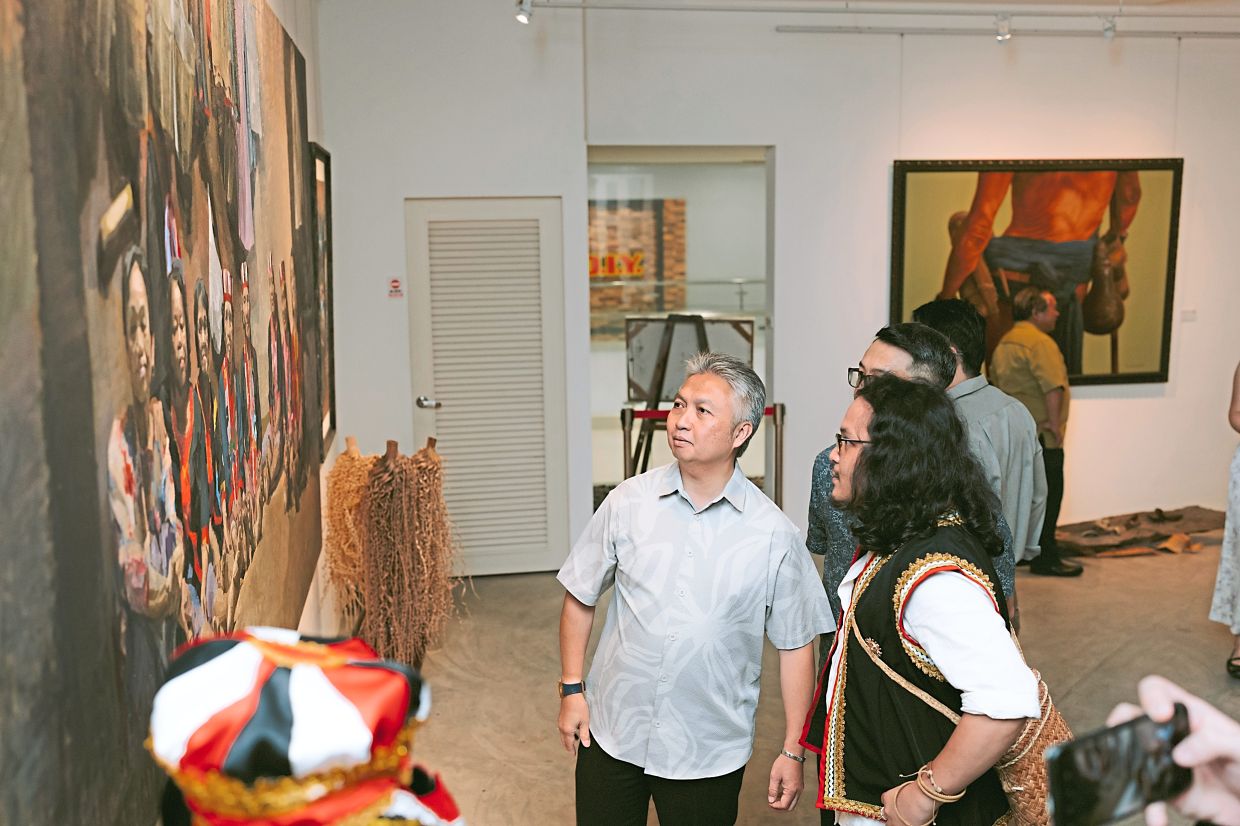 Deputy Tourism, Creative Industry and Performing Arts Minister Datuk Snowdan Lawan (left) touring the exhibition during the launch ceremony.