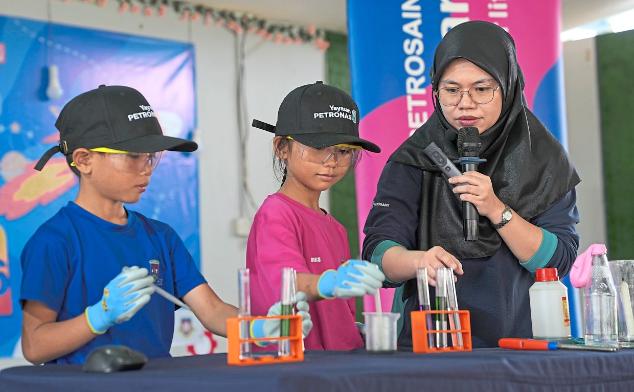 Two students participating in experiments during the science show.