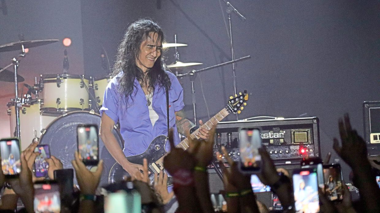 Search guitarist Kid performing at Rocktimatum Fest 2026 in Sandakan as fans capture the moment on their phones.