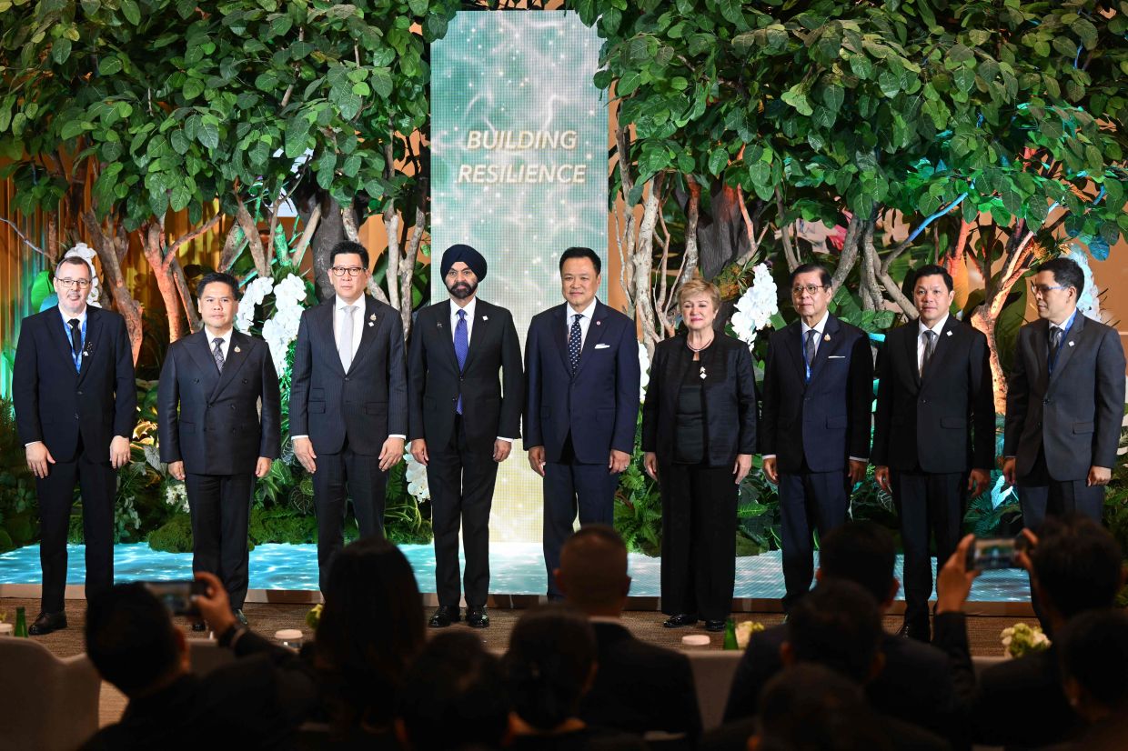 International Monetary Fund (IMF) Managing Director Kristalina Georgieva (4th R), Thai Prime Minister Anutin Charnvirakul (C), World Bank Group President Ajay Banga (4th L), Thailand's Deputy Prime Minister and Minister of Finance Ekniti Nitithanprapas (3rd L), and Minister of Industry Varawut Silpa-archa (2nd L) pose for a group photo with other officials during the opening ceremony of -- The Royal Legacy: Empowering People, Building Resilience -- exhibition on the opening day of the 2026 Annual Meetings of the International Monetary Fund (IMF) and the World Bank Group (WBG) at the Queen Sirikit National Convention Center (QSNCC) in Bangkok on October 12, 2026. The week-long global financial summit, hosted by Thailand from October 12 to 18, brings together over 15,000 finance ministers, central bank governors, economic leaders, and economists from 191 member countries to discuss global economic growth, financial stability, and sustainable development. Finance ministers and central bankers meet in Bangkok this week for the annual gatherings of the International Monetary Fund and World Bank, with the global economy buffeted by the US-Iran war's energy shock, rising debt pressures, and the AI boom.-- Photo by Panumas Sanguanwong / AFP
