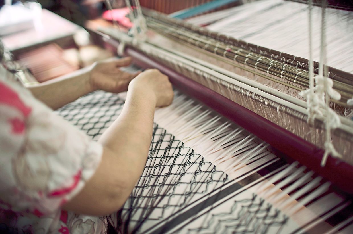 Weaving the keffiyeh made from traditional Lao mulberry silk.