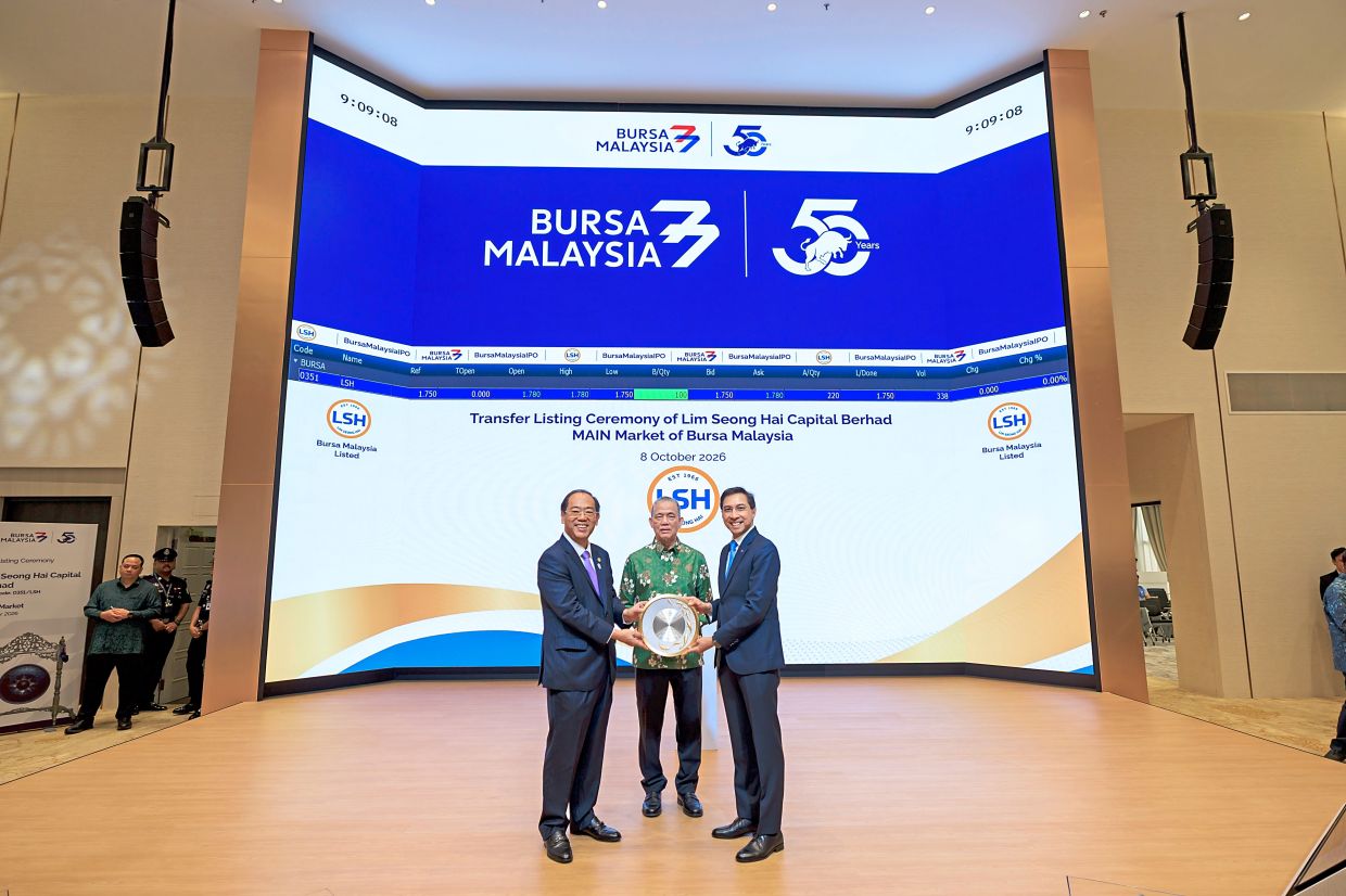 Appreciation gesture: Keng Cheng (left) handing over a token of appreciation to Bursa Malaysia chief executive officer Datuk Fad’l Mohamed, witnessed by Fadillah, after the transfer listing ceremony in Kuala Lumpur.