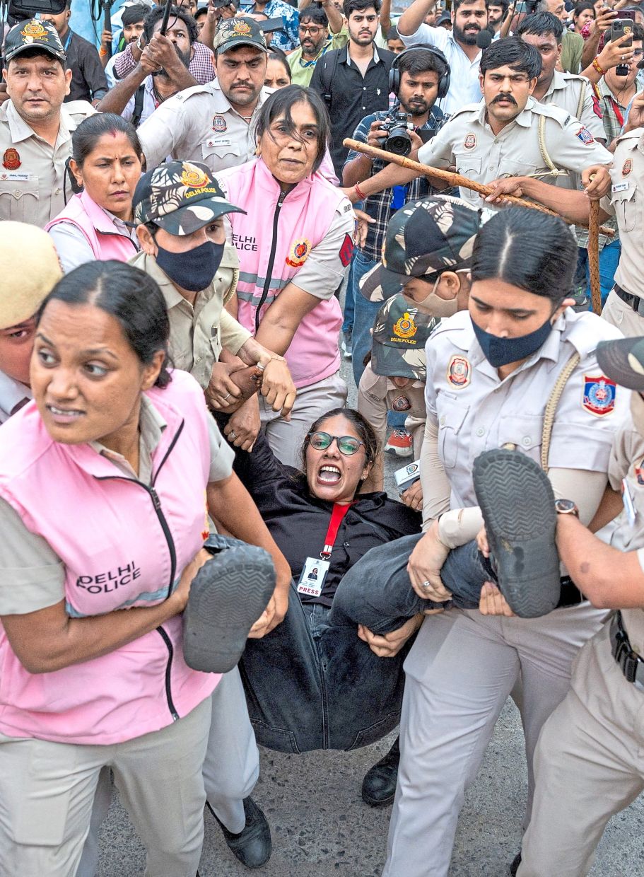 Press silenced: Security personnel and police detaining a journalist during a protest by the CJP. — Reuters