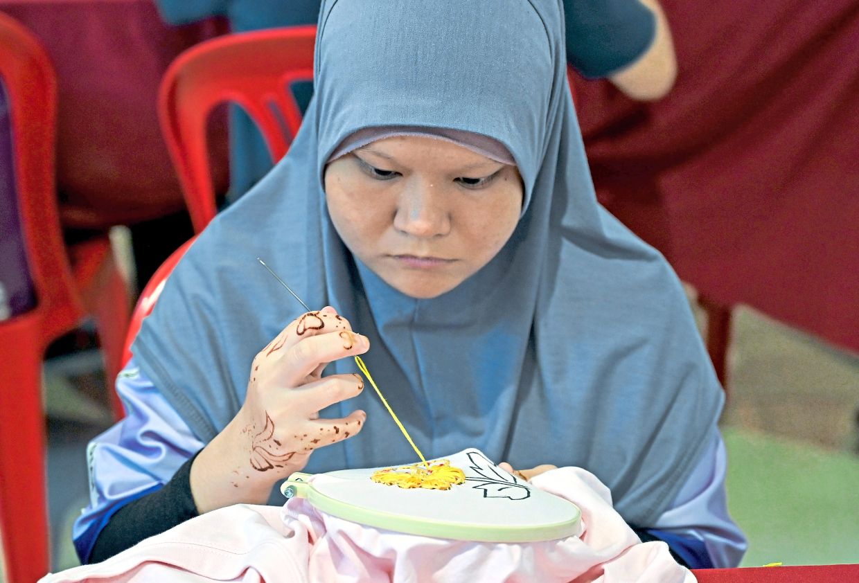 A participant of the embroidery competition focused on her work.