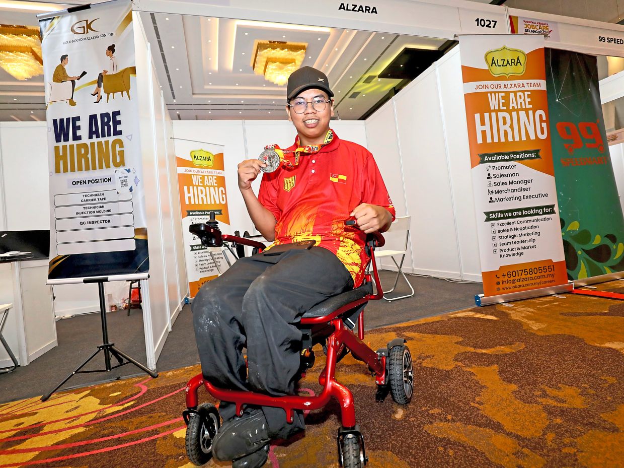 Attending the job fair at the MBSA Convention Centre, Muhammad Nor Azmeer showing the silver medal he won for boccia at Para Sukma 2026.