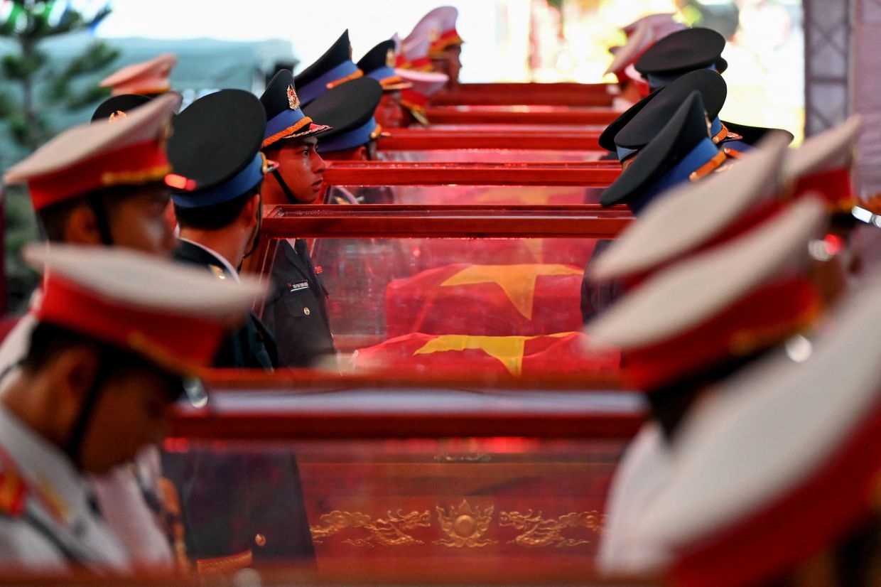 Soldiers stand beside caskets bearing the remains of fallen soldiers at Le Thi Rieng Park in Ho Chi Minh City on October 14, 2026. Vietnam held funeral rites for more than 700 of its war dead on Oct 14, unearthed in a major push to identify those missing from decades of conflict with France and the United States. - Photo: AFP