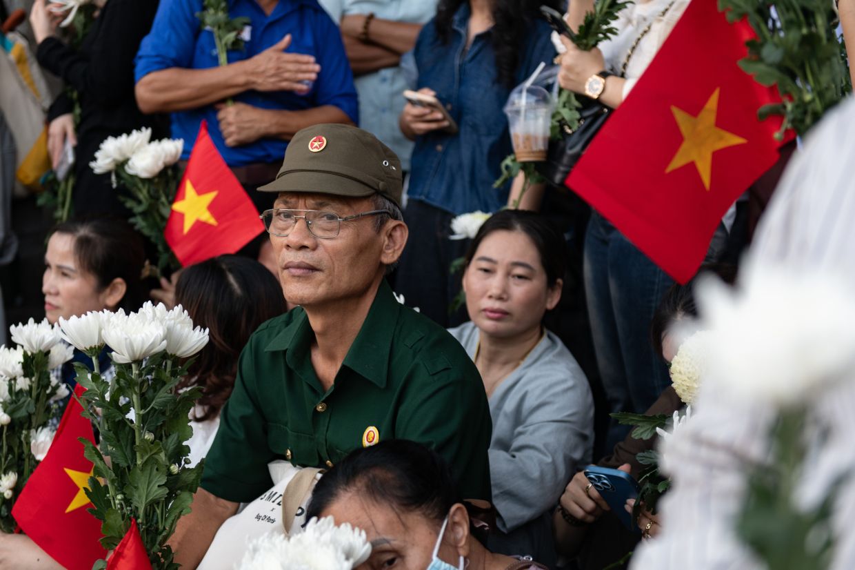 People watch as 731 sets of martyrs' remains found at Le Thi Rieng Cultural Park are transferred for burial at Ho Chi Minh City Martyrs' Cemetery Wednesday, Oct 14, 2026, in Ho Chi Minh City, Vietnam. - Photo: AP