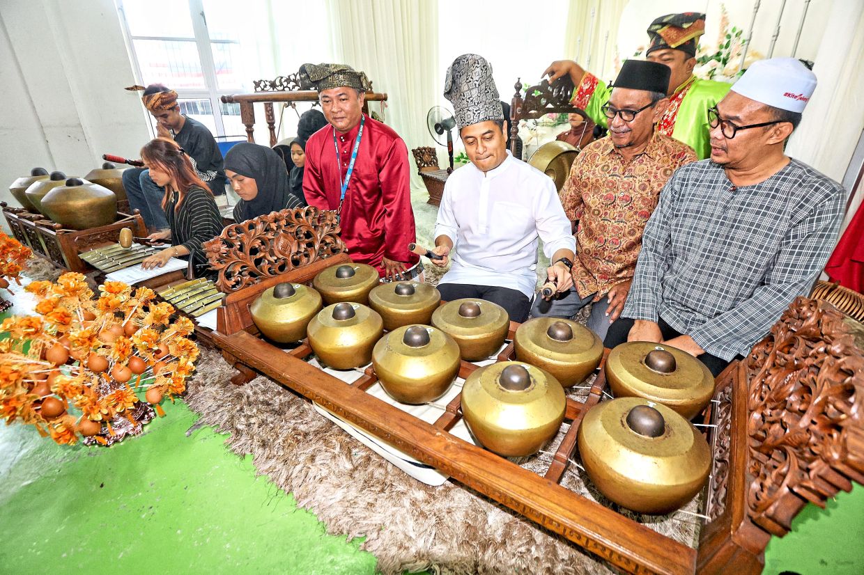 (From second left) Fahmi playing the gamelan as Nordin and Petaling Jaya City Council councillor Mohamad Azli Jamaasim look on.