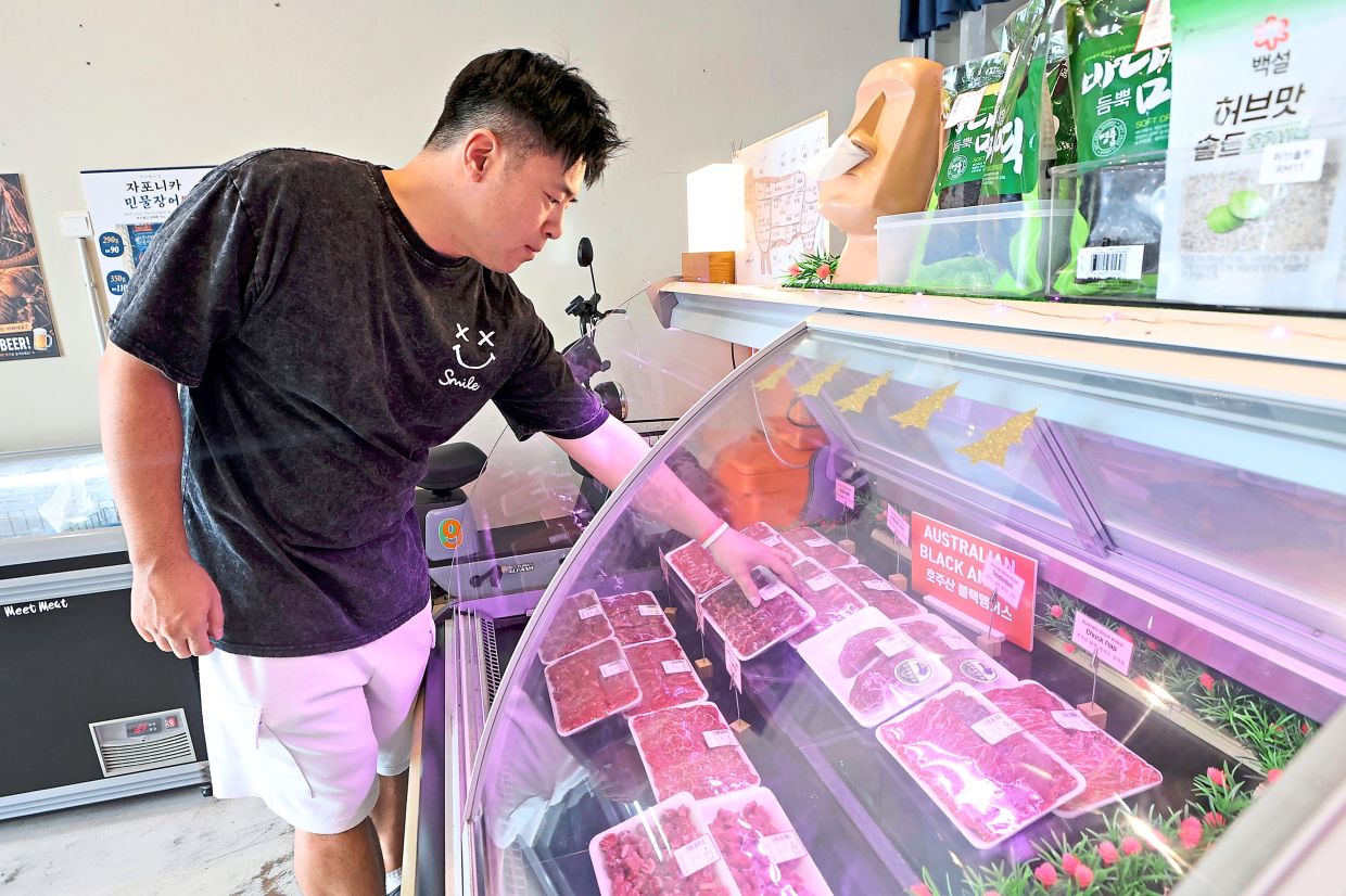 Son arranging the meat used for Korean barbecue, at his shop in Iskandar Puteri.