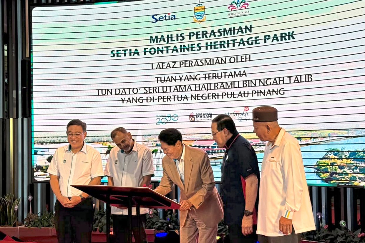 Ramli signing the board to launch Setia Fontaines Heritage Park in Kepala Batas. From left are Wong, Jafri, Zaini and Bukhori.