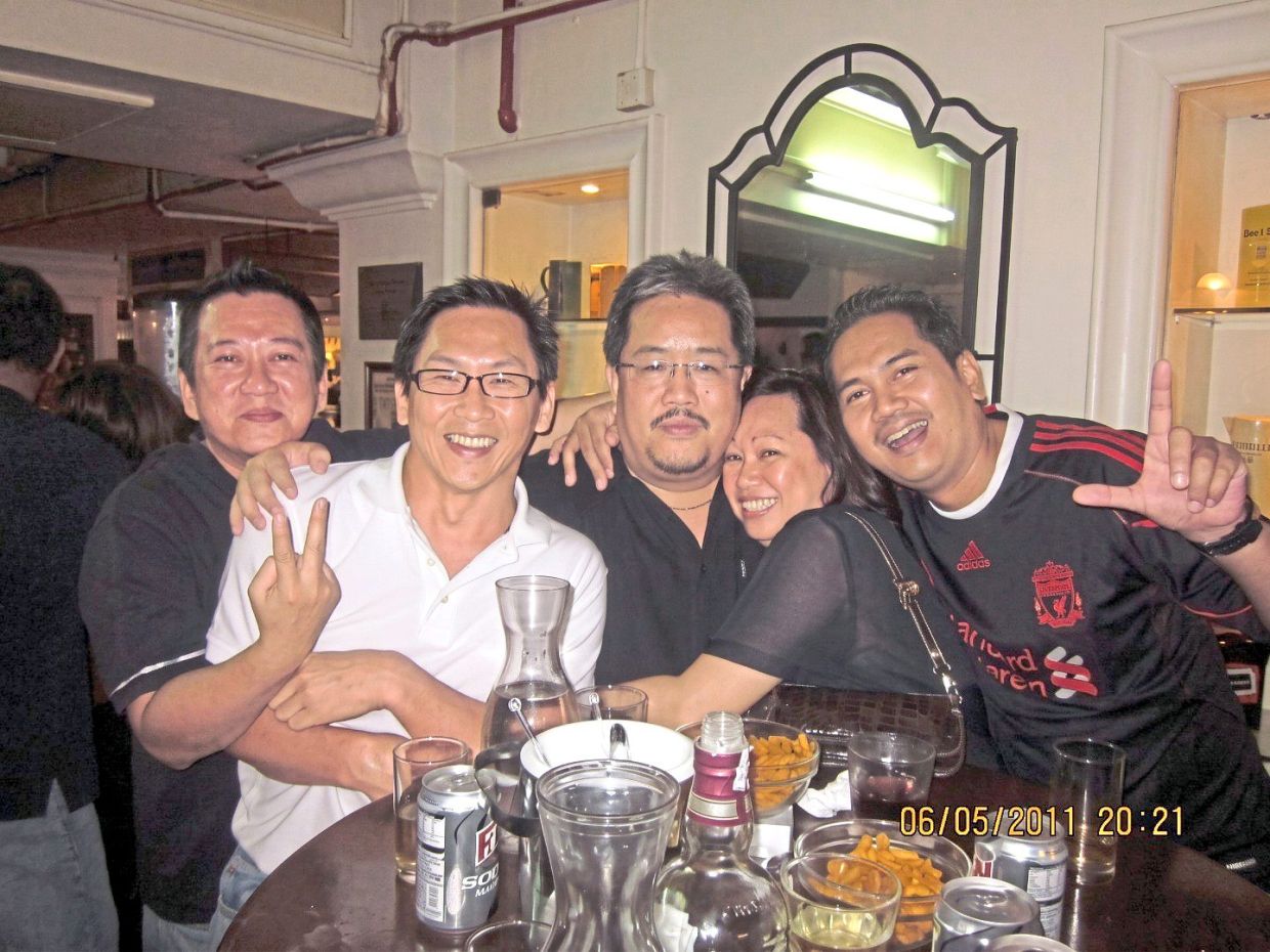 Roland (right) with his friends at a football viewing party in 2011.