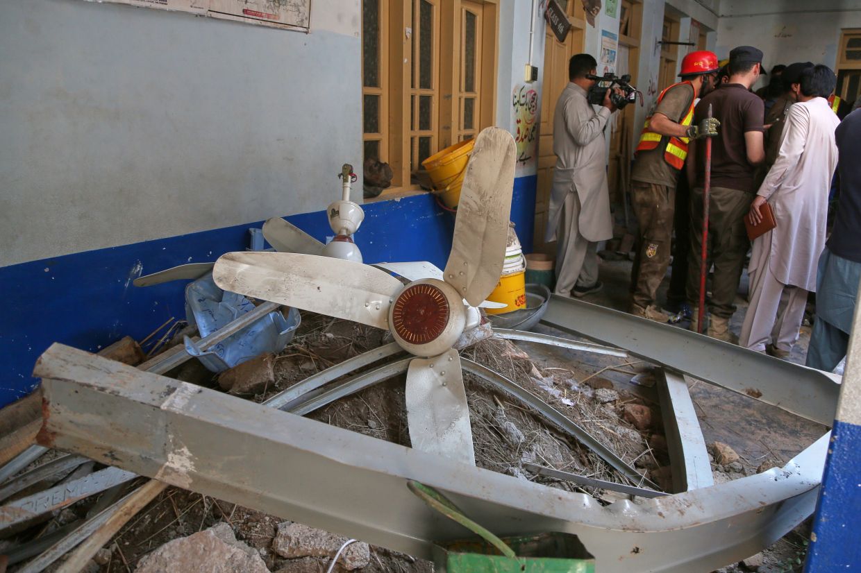 Rescue workers take a break while searching through the rubble at the site of a roof collapse at a private school, in Peshawar,Pakistan, Thursday, Oct. 15, 2026. - Photo: AP