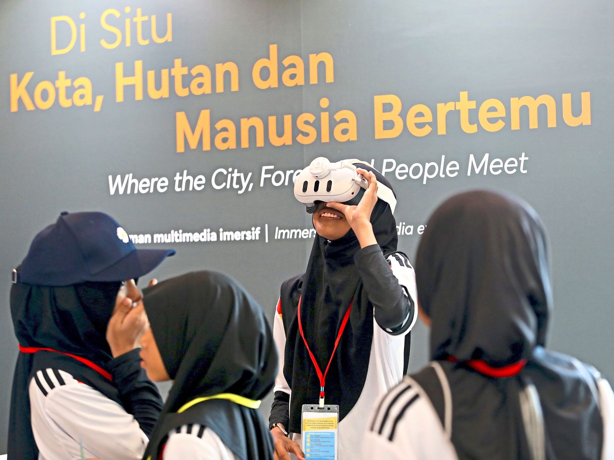 A schoolgirl tries out the exhibition’s VR 360° experience of KL at the exhibition. Photo: The Star/Leong Wai Yee