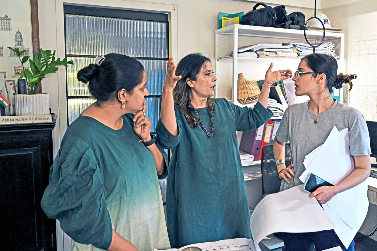 Abha (centre) discussing a project design with heritage researchers in Mumbai. Photo: AFP 