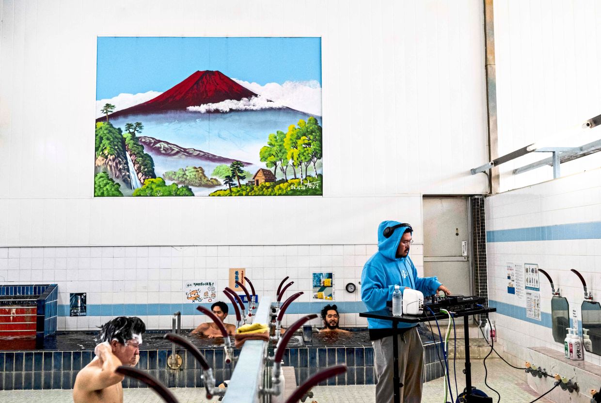 DJ Zendo performs a set as part of the Login.jp project as people bathe at the Electric Water Heater sauna in Sumida, Tokyo.