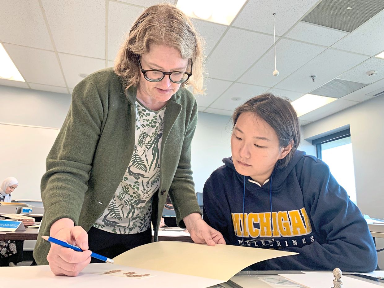 Kaye (left) has a discussion with Jiang at the University of Michigan.