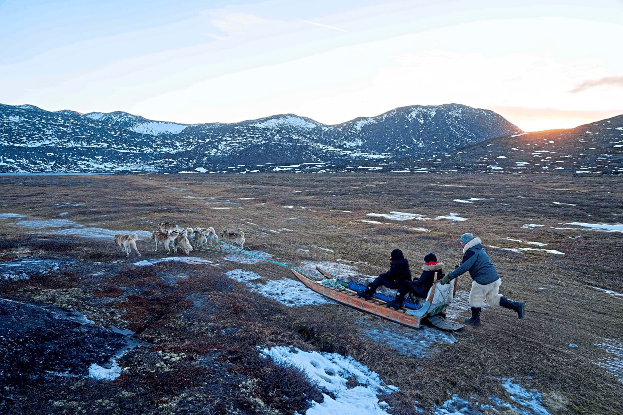 Jorgen Kristensen rides with his sled dogs in Ilulissat, Greenland.