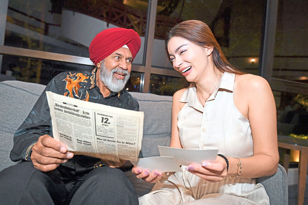 Dr Gurcharan and Sandra looking through newspaper clippings reporting her in-flight birth during their meeting in Kuala Lumpur. — IZZRAFIQ ALIAS/The Star 
