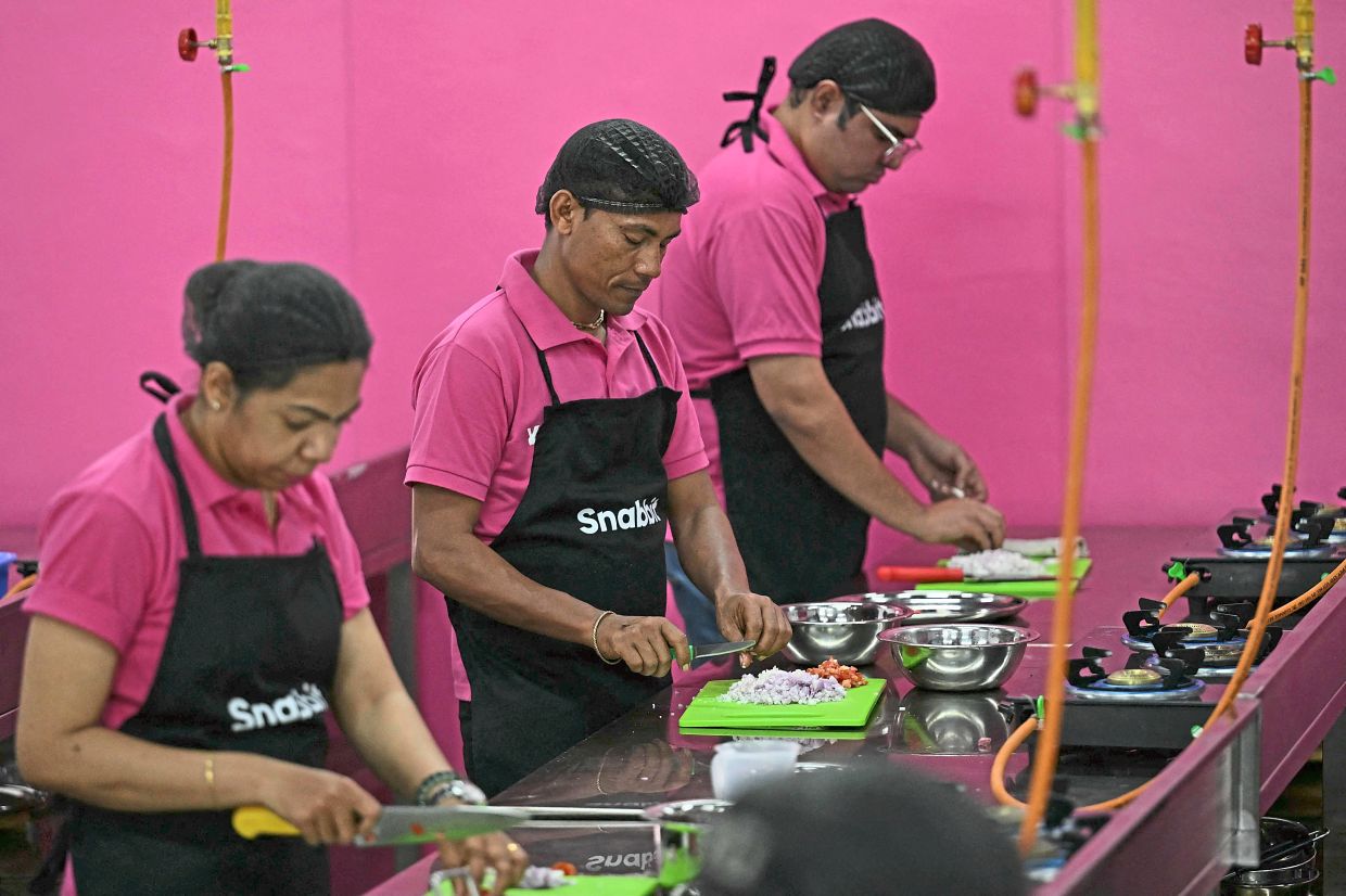 Work revolution: Snabbit employees cooking; and (below) making beds at the company’s training centre in Bengaluru. — AFP