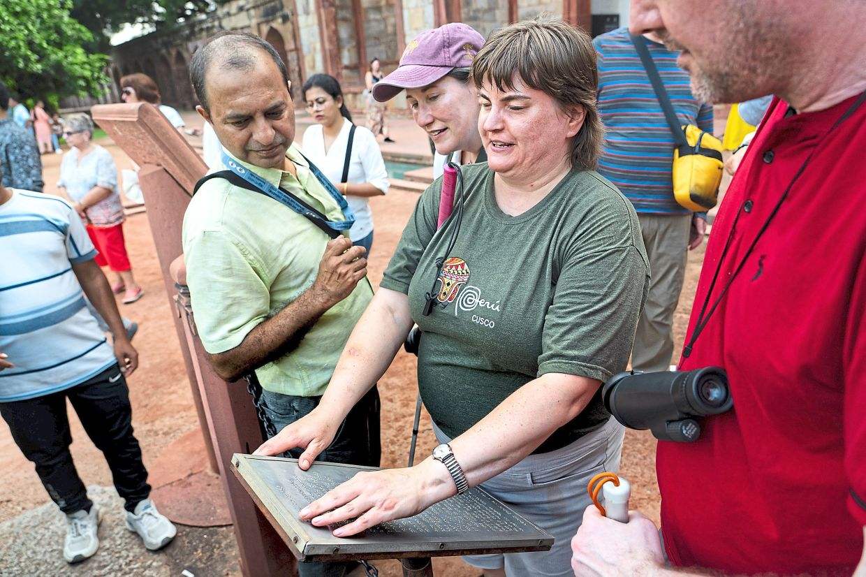 Candie reading an information plate in Braille at Humayun’s Tomb, a 16th-century Mughal mausoleum in Dehi.