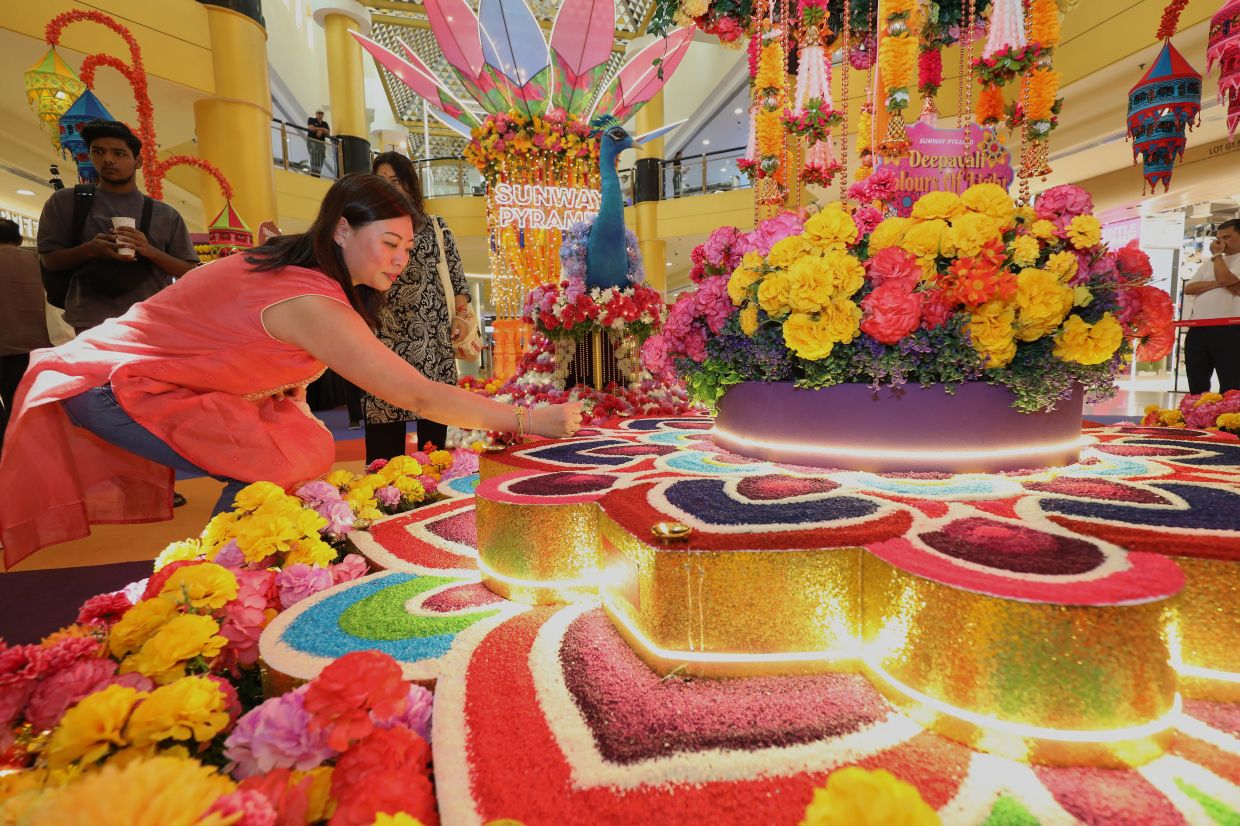 Teng is adding the final touches to the ‘kolam’.